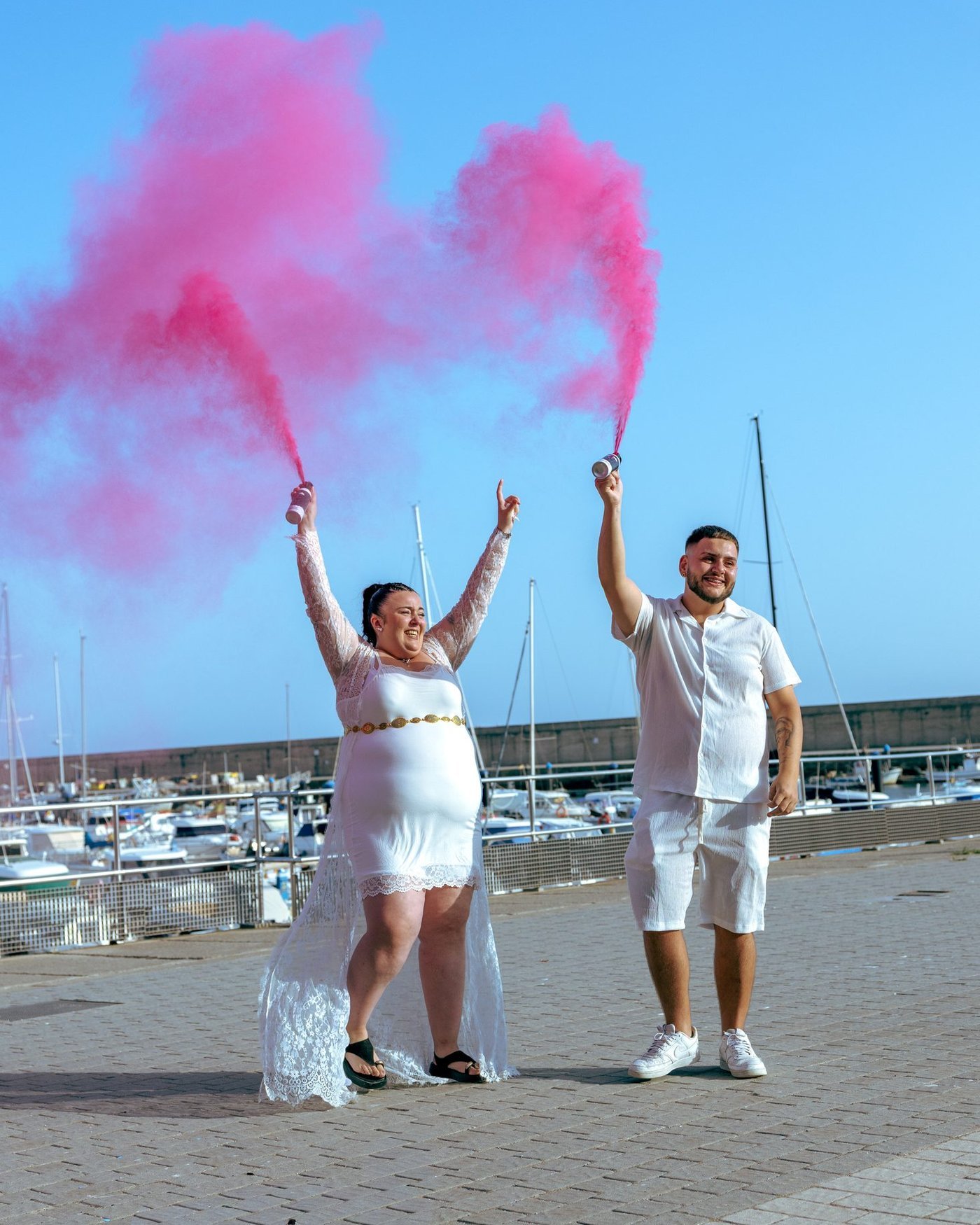 Pareja levantando los botes de humo rosa en el puerto